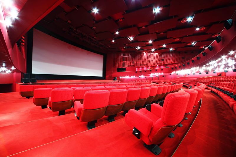 comfortable red chairs in illuminate red room cinema IMAX